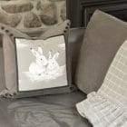 My rabbit friends cushion with the gray Frisson throw on a gray sofa.