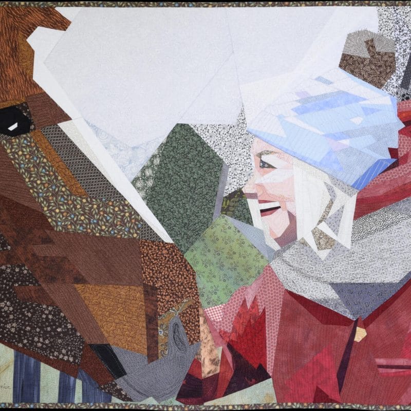 La rencontre textile art piece showing a smiling girl face to face with the head of a horse.