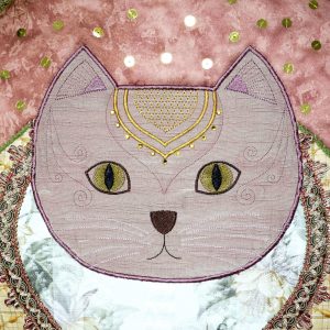 Detail of the Ronronnet cushion. Face of a cat in embroidered satin and decorated with Swarovskis stones.
