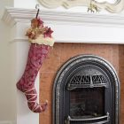 Christmas stocking Lady Guinevere hanging from a fireplace and decorated with Christmas accessories.