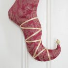 Detail of the Christmas stocking Lady Guinevere, curved foot with gold satin ribbon and golden beads.