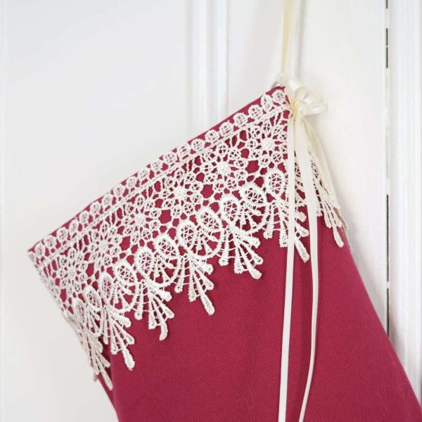 Detail of the Christmas stocking Princess Cyrielle, ivory lace cuff on a red background.