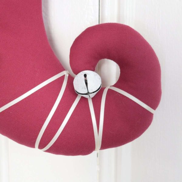 Detail of the Christmas stocking Princess Cyrielle, Curved foot with white ribbon and white bell.