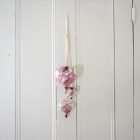 A trio of hearts in red toile hanging on a white door.