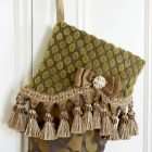 Christmas stocking Zefirino detail, gold textured velvet lapel with tassel fringe and satin bow.