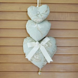 Trio of hearts in green and ivory fabric.