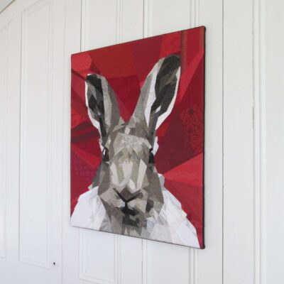 Tableau d'art textile Nice to meet you. Portrait d'un lièvre sur fond rouge.