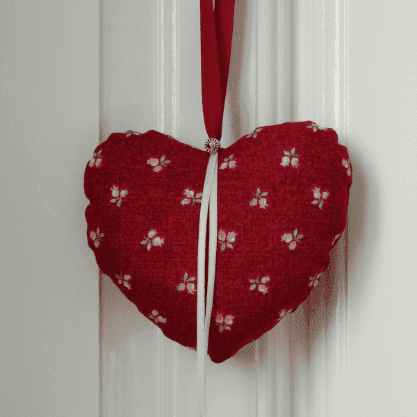 Coeur en tissu imprimé rouge avec boutons de roses et ruban rose pâle
