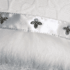 Perles bleu pâle et feuilles de houx en métal sur un ruban de satin argent.