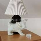 Decorative dog toile de Jouy green on a bedside table against a lamp