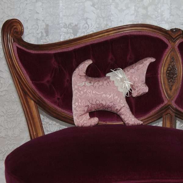 Pillow in the shape of a pink dog on a Victorian armchair