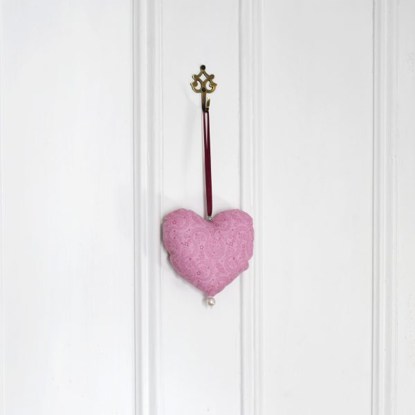 Pink fabric heart hanging from a door