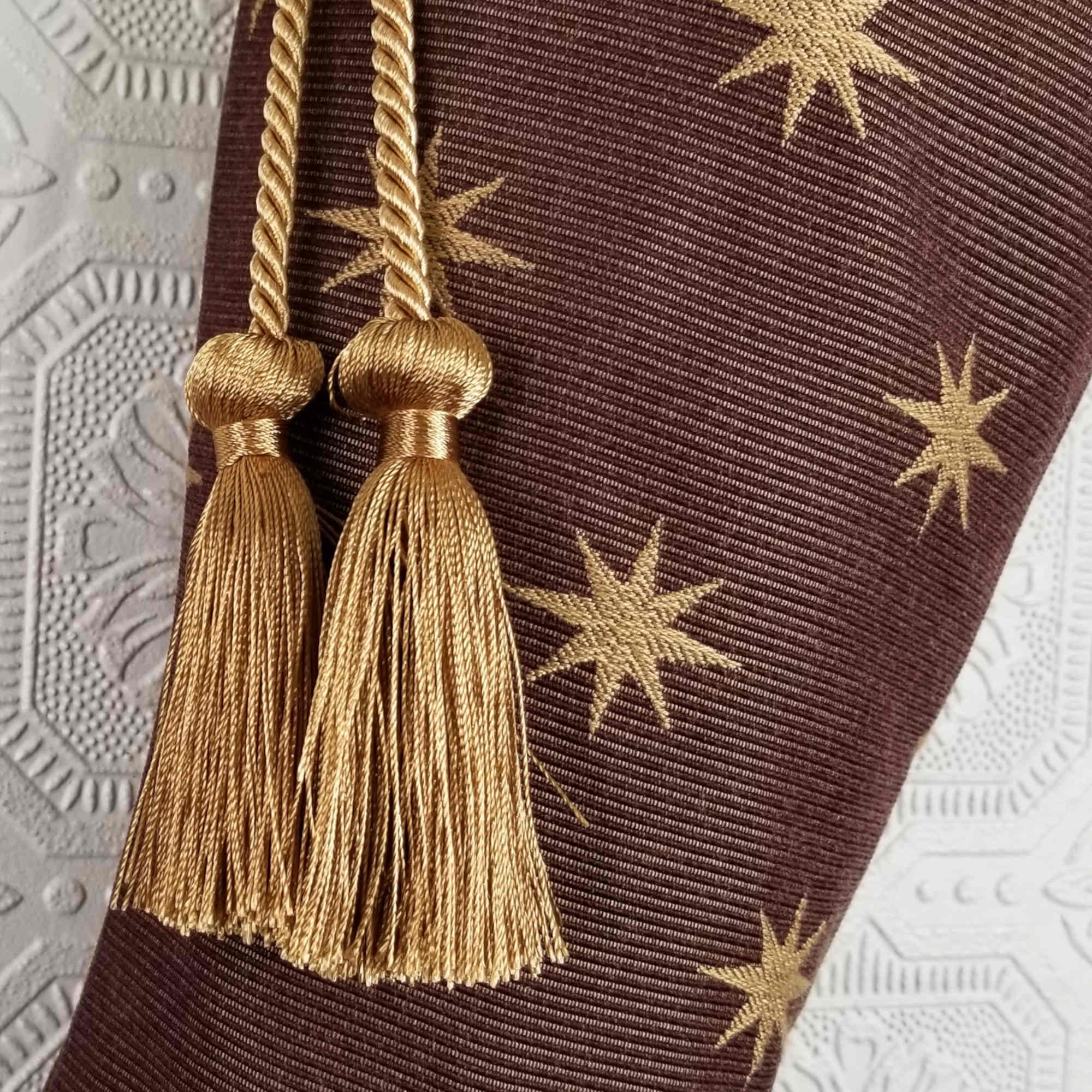 Detail of Melchior Christmas stocking, gold tassels on brown fabric with gold stars
