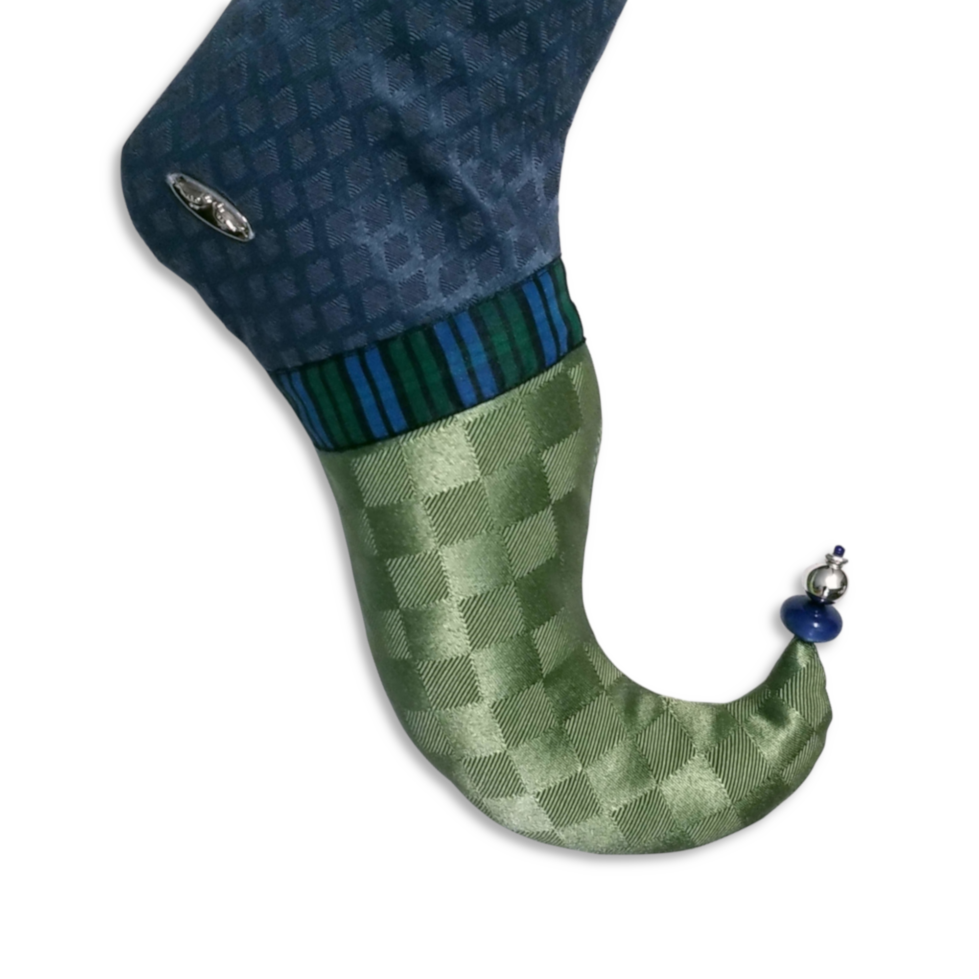 Pied courbé du bas de Noël Willi en jacquard vert avec un ruban en plaid bleu et vert. Le pied se termine en pointe avec des perles bleues et argent.