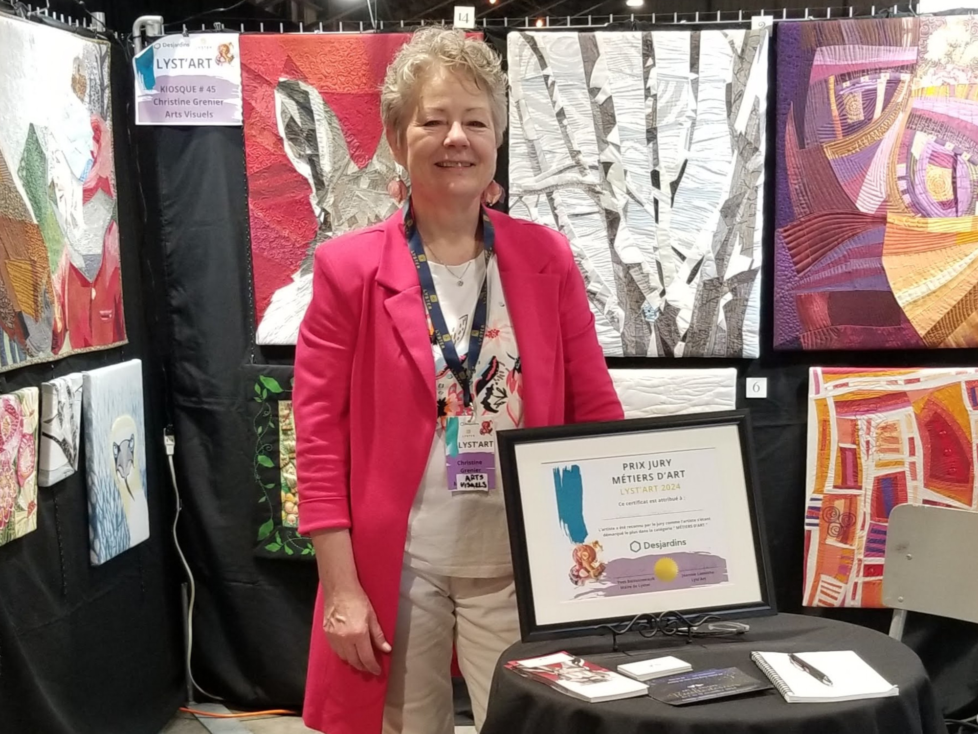 Christine Grenier in her booth at Lyst'Art with her jury prize.