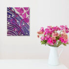 Tableau d'art textile Aller vers soi sur un mur blanc à côté d'un bouquet de fleurs roses et jaunes dans un vase blanc.