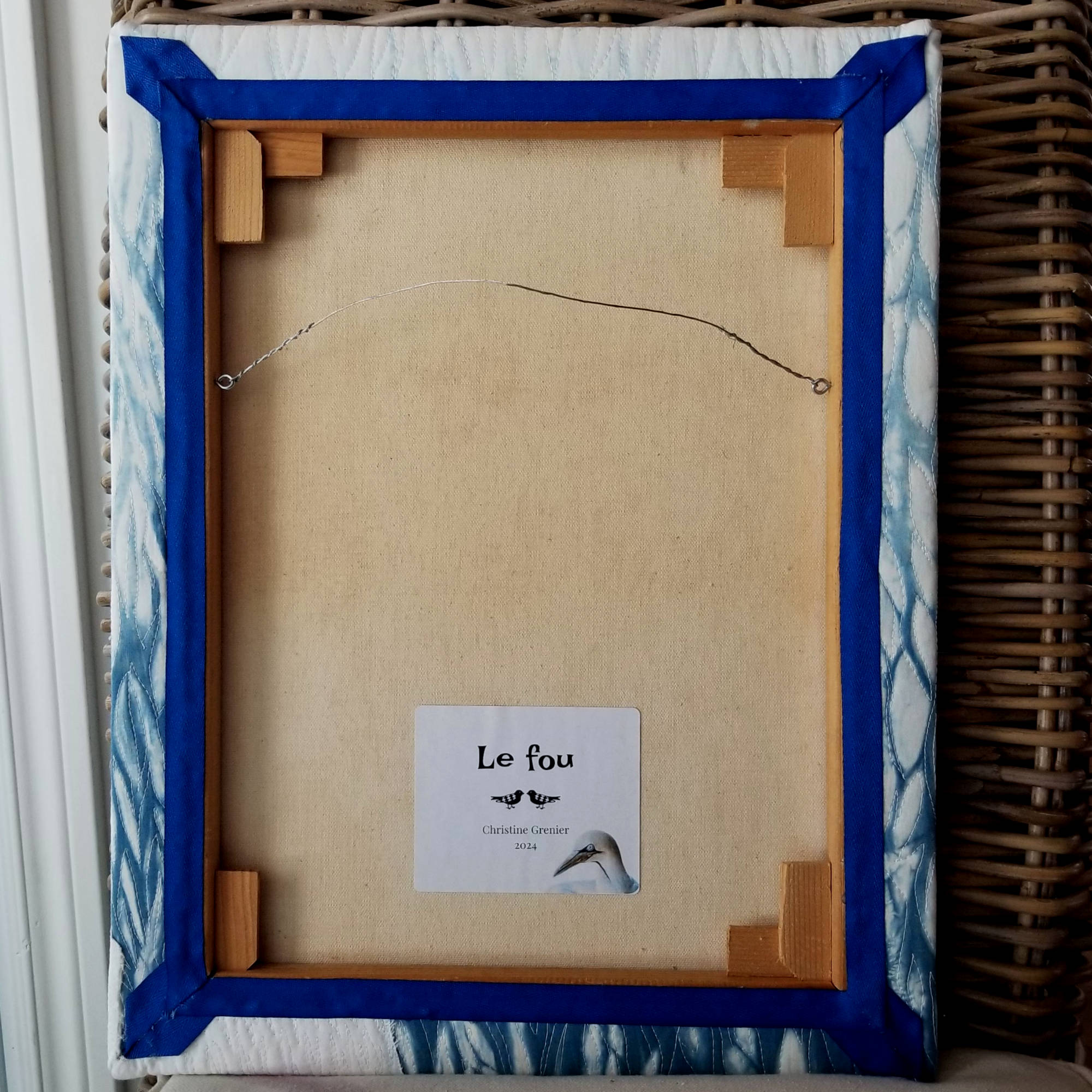 Envers du tableau d'art textile Le fou par Christine Grenier montrant la finition impeccable du tableau.