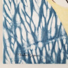 Détail du tableau d'art textile Le fou, tissu teint à l'indigo en technique de shibori, signature de Christine Grenier.