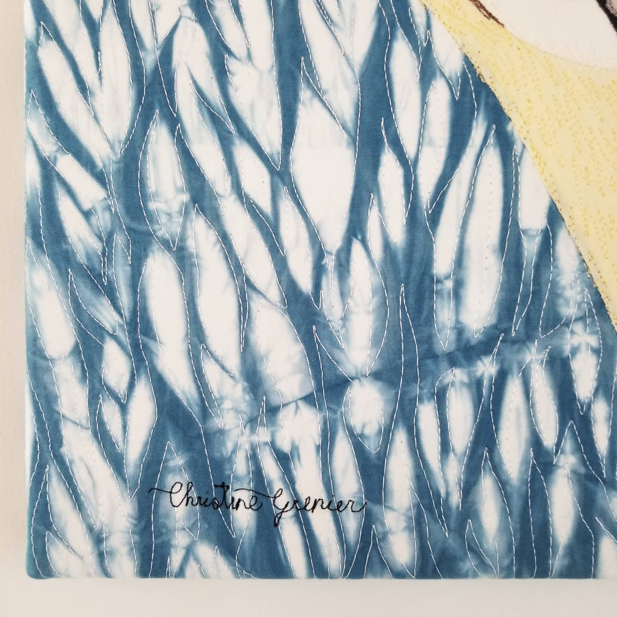 Détail du tableau d'art textile Le fou, tissu teint à l'indigo en technique de shibori, signature de Christine Grenier.