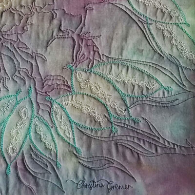 Détail du tableau Mémoires d’un temps oublié, montrant la signature de l’artiste Christine Grenier et textures du tissu brodé.