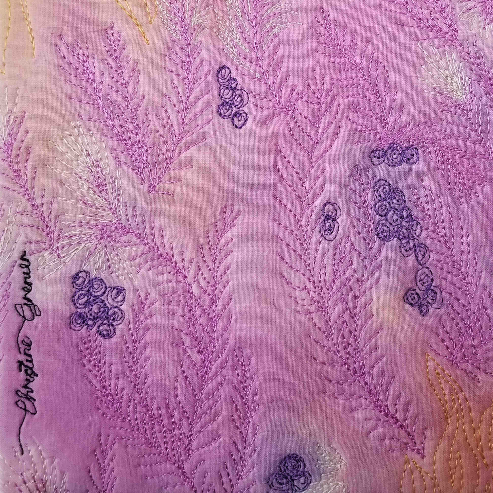 La mémoire du vent – Détail du tableau textile montrant les motifs brodés et la signature de Christine Grenier.