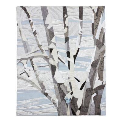 Ce paysage d'hiver est un tableau d'art textile présentant un érable aux branches recouvertes de neige.