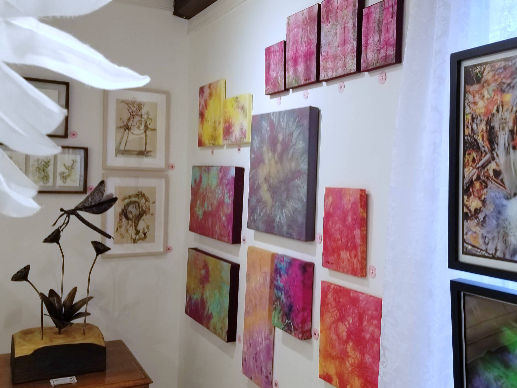 Galerie Boutique Christine Grenier, vue des tableaux textiles et d'autres artistes, sculptures de métal et de tissu.